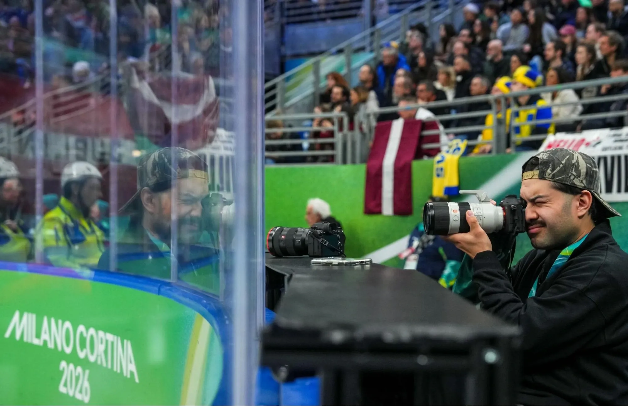 Juan Morales photographing a hockey game courtside at the Milano Cortina 2026 Olympics