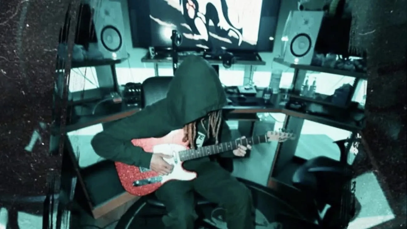 Raymond Herring playing guitar in his home studio