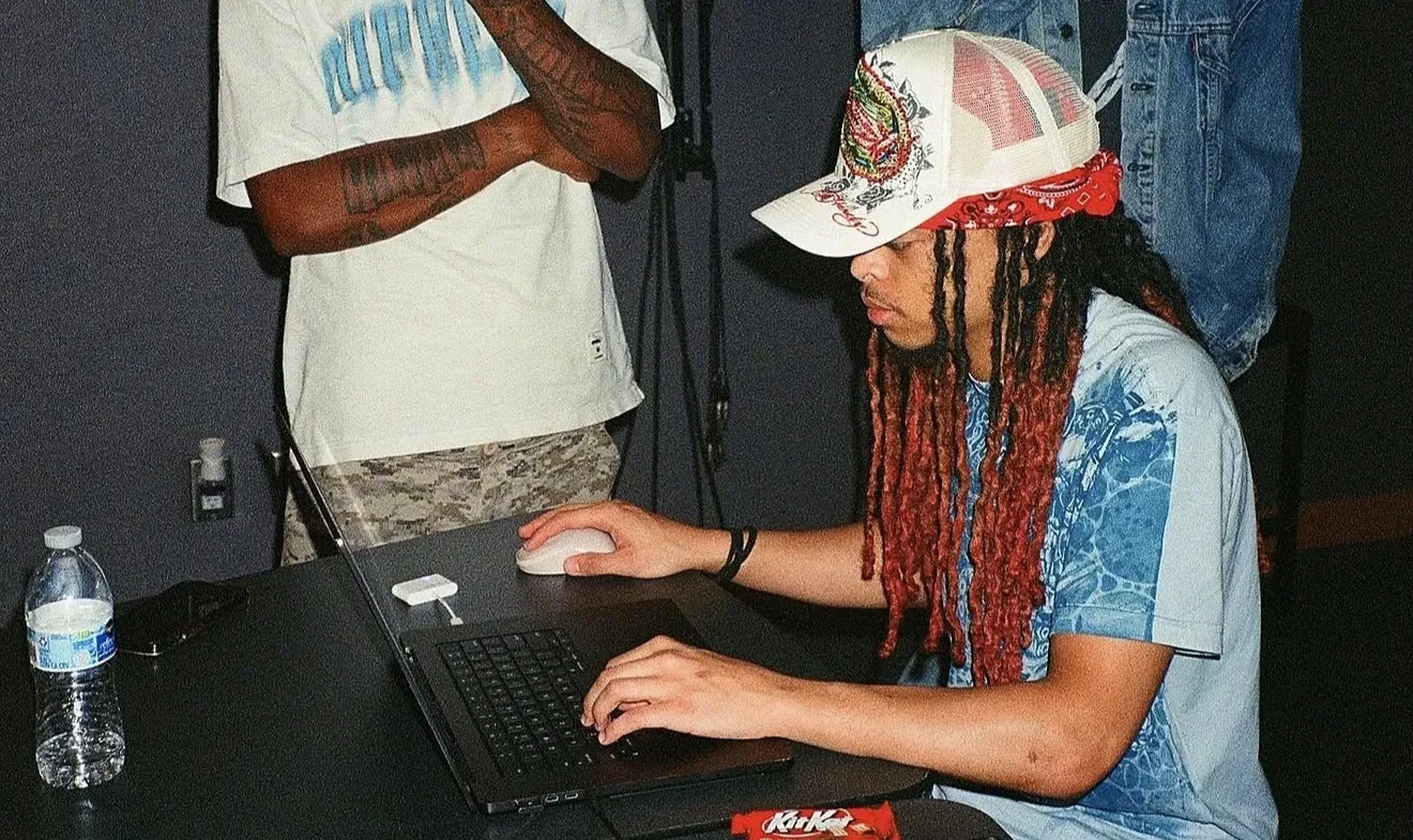 Raymond Herring working on a laptop with a friend nearby